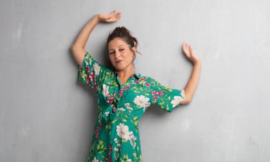 Senin konseptin yerleştirmek için çimento duvar arka plan boşluk ile poz genç güzel kadın