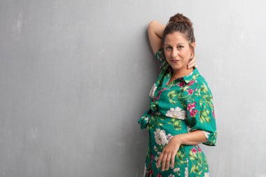 Senin konseptin yerleştirmek için çimento duvar arka plan boşluk ile poz genç güzel kadın