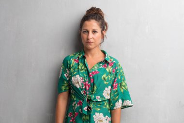 Senin konseptin yerleştirmek için çimento duvar arka plan boşluk ile poz genç güzel kadın