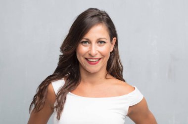 Senin konseptin yerleştirmek için çimento duvar arka plan boşluk ile poz genç güzel kadın