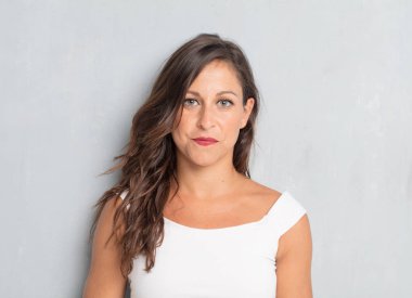 Senin konseptin yerleştirmek için çimento duvar arka plan boşluk ile poz genç güzel kadın