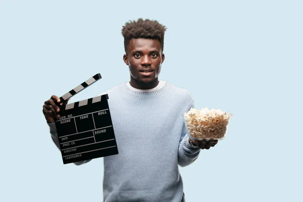 Young black man with popcorn. Cinema concept.