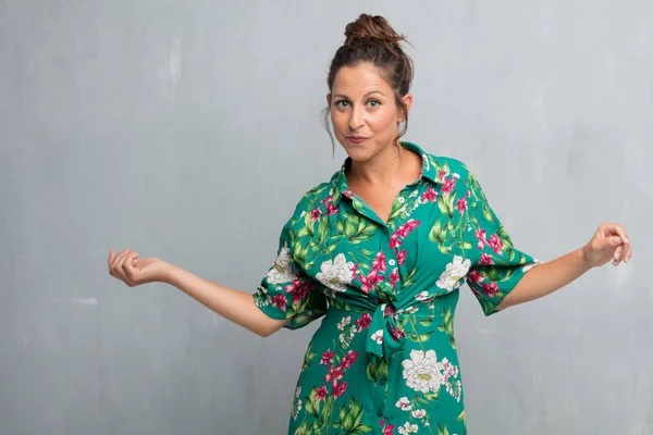 Senin konseptin yerleştirmek için çimento duvar arka plan boşluk ile poz genç güzel kadın