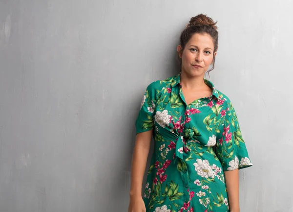 Senin konseptin yerleştirmek için çimento duvar arka plan boşluk ile poz genç güzel kadın