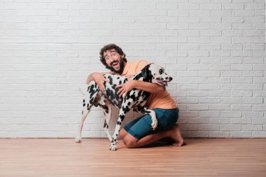Genç sakallı adam beyaz tuğla karşı Dalmaçyalı köpekli duvar arka plan