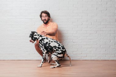 Genç sakallı adam beyaz tuğla karşı Dalmaçyalı köpekli duvar arka plan