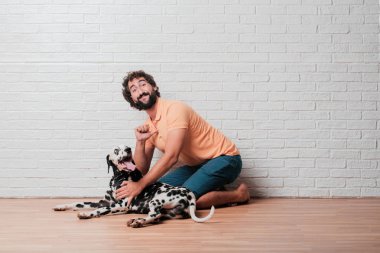 Genç sakallı adam beyaz tuğla karşı Dalmaçyalı köpekli duvar arka plan
