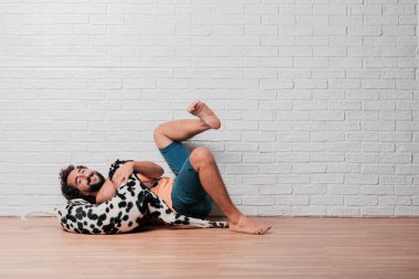 Genç sakallı adam beyaz tuğla karşı Dalmaçyalı köpekli duvar arka plan