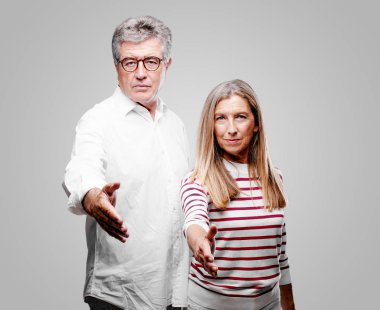 üst düzey serin karı koca bir anlaşma, kapanış veya selamlama ve sizi karşılayan bir el sıkışma, sunan ciddi, kendine güvenen, gurur ve sert bir ifade ile.