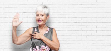 tek eliyle kalp üzerinde ciddiyetle küfür samimi söz ver yoksa yemin, yaparken güvenle gülümseyen güzel kadın kıdemli.