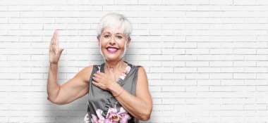 tek eliyle kalp üzerinde ciddiyetle küfür samimi söz ver yoksa yemin, yaparken güvenle gülümseyen güzel kadın kıdemli.