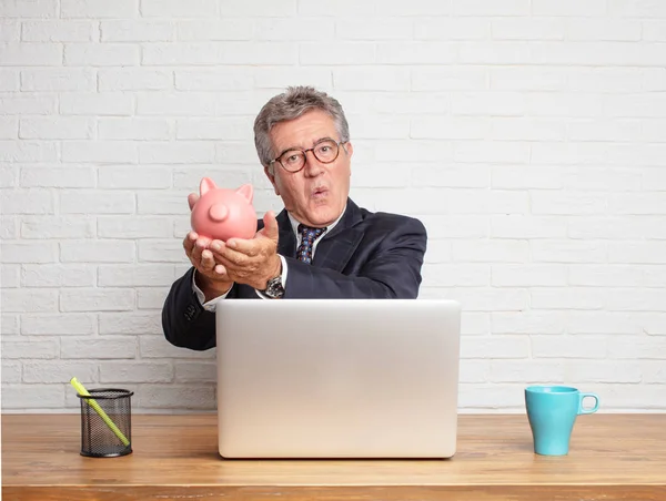 Hombre Negocios Senior Trabajando Con Portátil Sosteniendo Una Alcancía Concepto — Foto de Stock