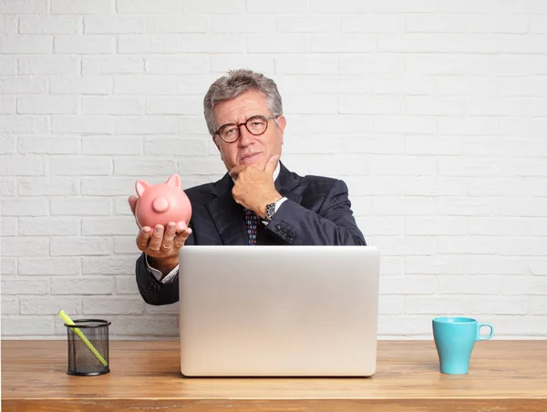 Hombre Negocios Senior Trabajando Con Portátil Sosteniendo Una Alcancía Concepto — Foto de Stock