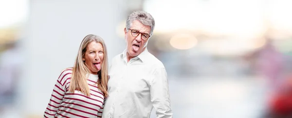 高级酷的丈夫和妻子开玩笑 伸出舌头与一个有趣的 愚蠢的和好玩的表情 看起来像一个傻瓜 — 图库照片