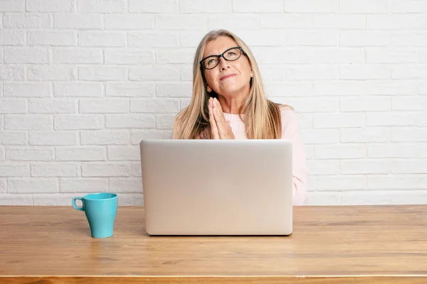 senior businesswoman praying in a saintly manner, begging 