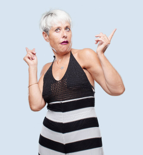 старшая классная женщина шутит, высунув язык со смешным, глупым и игривым выражением лица, выглядя как дурак
.