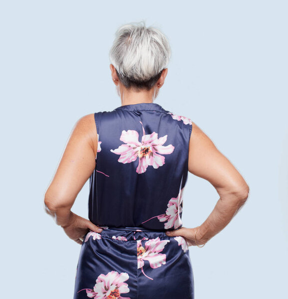 senior cool woman back view, both hands on hips with the akimbo pose, probably feeling proud and satisfied.