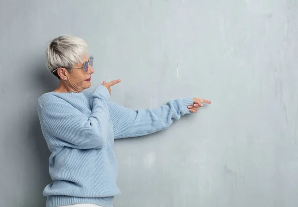 Coole Seniorin Zeigt Auf Leeren Platz Grunge Zementwand — Stockfoto