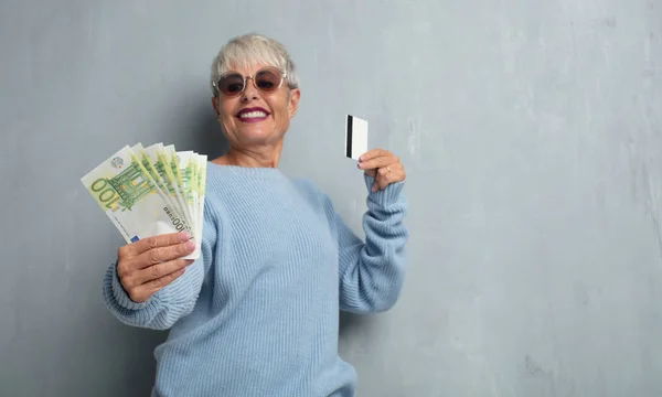 Senior Cool Vrouw Met Een Credit Card Tegen Grunge Cement — Stockfoto