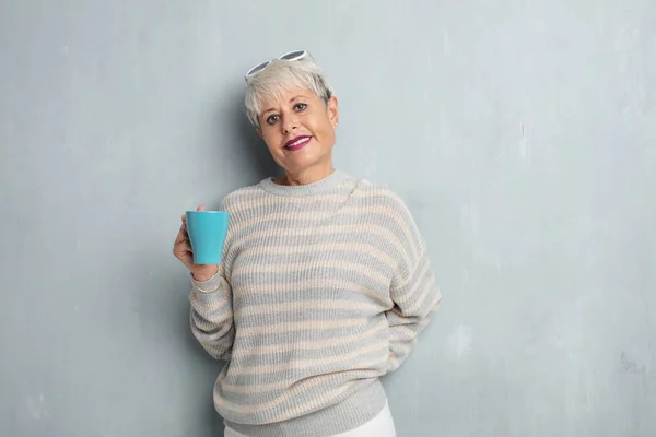 Senior Cool Kvinna Med Kaffe Mot Grunge Cement Vägg — Stockfoto