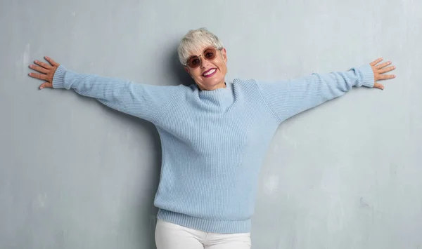 senior cool woman against grunge cement wall.