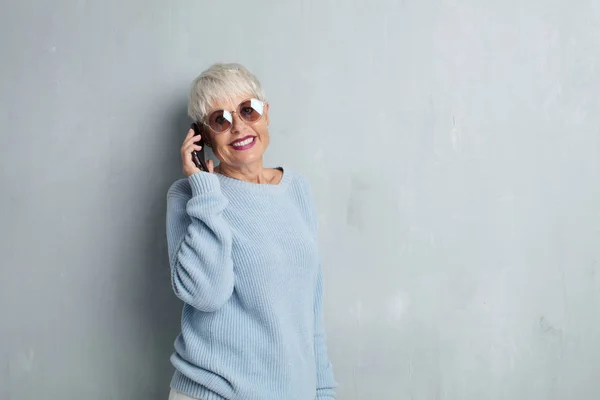 Senior Cool Kvinna Med Smartphone Mot Grunge Cement Vägg — Stockfoto