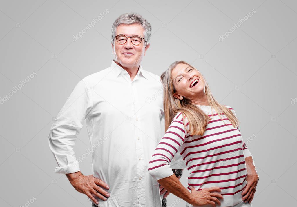 senior cool husband and wife smiling proudly and confidently with arms hands on hips in akimbo pose, happy and sure of success, giving an 