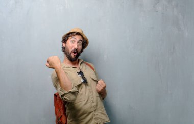 Genç yolcusu adam ya da turistik el zafer, yüz ve holding kol gücü veya bir başarı kutluyor başarı gösteren basıldığında, yumruk ile mutlu, gururlu ve memnun bir bakışla.