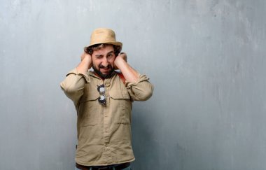 Genç yolcusu adam ya da her ikisi ile turistik gürültü rahatsız edici bir rahatsız, yüksek sesle, onları korumak için kapak kulakları eller.