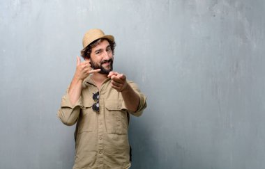 Genç yolcusu adam veya bir telefon görüşmesi jest veya işareti, gurur, mutlu, memnun bir bakışla yapma turist; ileri doğru işaret eden bir gülümseme ile iletişim sunan.