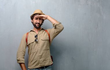 mesafe içine uzakta görünen genç yolcusu adam şaşkın bir bakışla uzak bir nesne için arama.