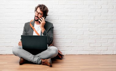 bir dizüstü bilgisayar ile katta oturan genç sakallı işadamı