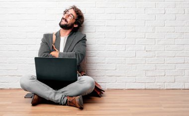 Kameranın önünde bir nesne doğru seyir çarpı işareti, silah ile ayakta, geri vererek katta oturan genç adam. Kızgın, memnun, gurur, düşünceli küstah ifade olabilir.