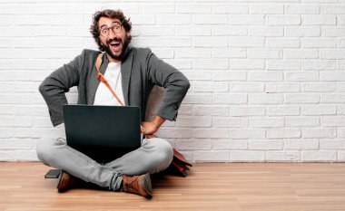 gurur, memnun ve mutlu bir görünüm ile katta kalça üzerinde iki eliyle sanki güvenle bakan bir meydan okuma oturan genç adam. Akimbo silah geniş bir gülümseme ile poz. Öfkeli bir ifade olabilir. Geri ya da arka görünüm.