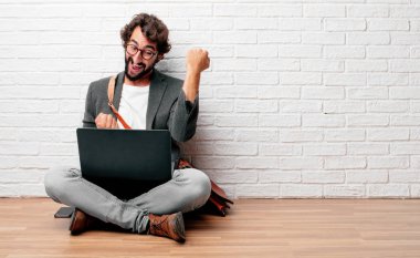 bir başarı kutluyor zafer, yüz ve holding kol gücü veya başarı, gösterilen basıldığında, yumruk ile mutlu, gururlu ve memnun bir bakışla mimik katta oturan genç adam.