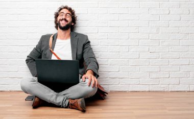 kat yüksek sesle baş geriye eğik ve mutlu, neşeli ifade ile gülüyor üzerinde oturan genç adam