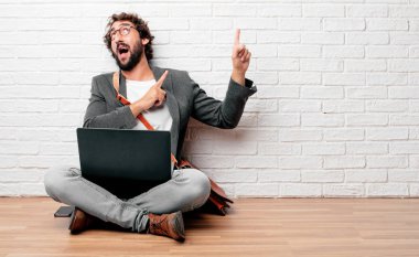 kat gülümseyerek oturan ve yukarı doğru nerede gazeteci bir kavram gösterebilir miyim yere doğru iki eliyle işaret eden genç adam.