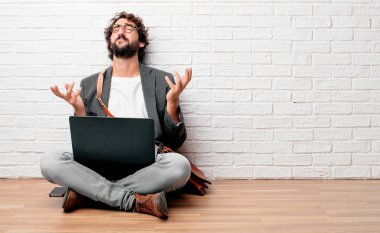 Genç adam stresli ve sinirli, yukarı doğru arıyor ve her iki el ele tutuşarak katta oturan açmak önünde dehşet ve güvensizlik ifade.