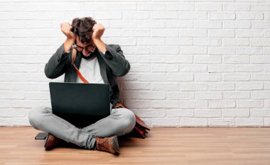 seyir katta oturan genç adam stresli ve sinirli, dehşet ve güvensizlik ifade.