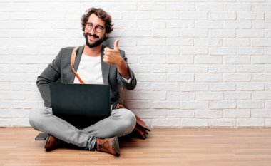 Tamam tek elle sinyal, bir pozitif, gönderme başparmak yukarıya, memnun, gururlu ve mutlu bir bakışla ile katta oturan genç adam 