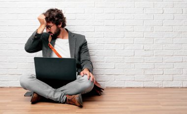 katta oturan genç adam Concentrating sert bir fikirle ciddi bir göz alnına işaret her iki işaret parmakları ile düşünüyor.