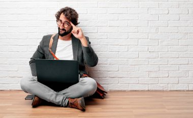 Genç adam bir fikirle de ciddi bir göz üzerinde konsantre ve aşağıya doğru karşı karşıya katta oturan alnına basarak sıkılı yumruk ile düşünme.