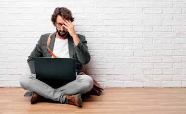 katta oturan genç adam açık ve alnına işaret parmağı kolu ile düşünme Concentrating uzak de ciddi bir göz, bir fikirle sert geçti.