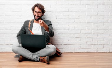 Genç adam ileriye dönük ve mutlulukla gülümseyerek yere oturmak tercih.