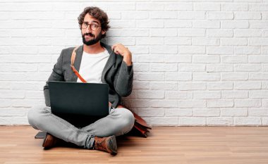 terleme ve gömlek boyun açık çekerek, kısık duygu stresli bir jest ile katta oturan genç adam.