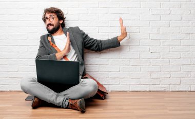 Dur her iki avuç ileri, ciddi ve sert bir ifade ile karşı karşıya el sinyal katta oturan genç adam yasaklayan. Orta yan cepheden görünüm.