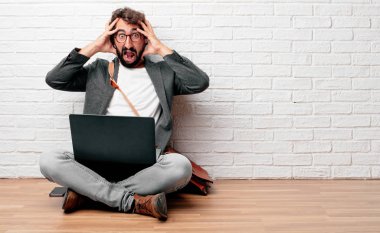 bir deli ile bağırarak katta oturan genç adam kafa iki eliyle tutarak sürpriz, görünümünü hayran.