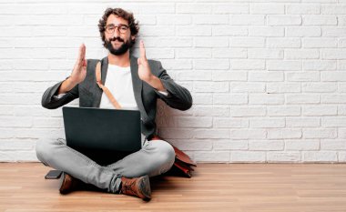 bir nesne veya önünde her iki el arasında düzenlenen kavramı gösterilen memnun bir ifade ile gülümseyen katta oturan genç adam.