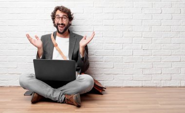 ifade ile mutlu bir katta oturan genç adam şaşırttı, gözleri geniş açık ve geniş gülümse, elle yüz şok gösterilen her iki tarafında.