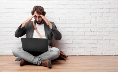 bir sürpriz ile katta oturan genç adam hayret ifadesi ve ağız şok açık.